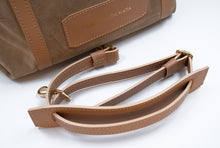 Încărcați imaginea în vizualizatorul Galeriei, Geantă maro din piele cu bretea pe fundal alb.

